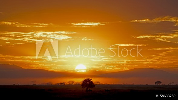 Image de Sun rising through rain clouds in Serengeti Tanzania